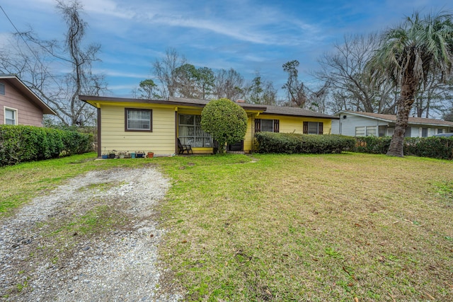 ranch-style home with driveway and a front yard