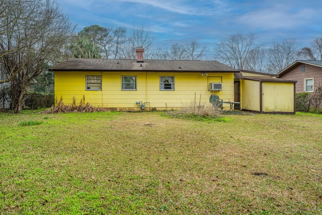 back of house with a wall mounted air conditioner, a yard, a chimney, and fence