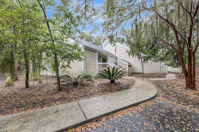 view of property exterior with roof with shingles and fence