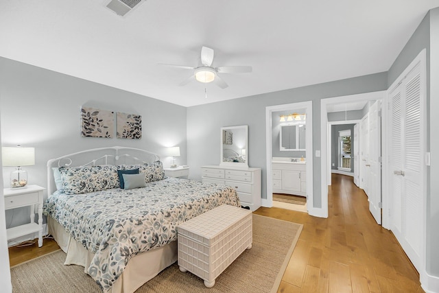 bedroom with visible vents, connected bathroom, ceiling fan, light wood-style floors, and a sink