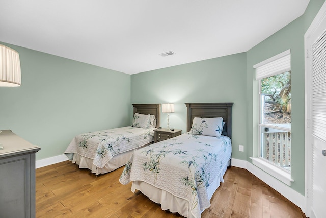 bedroom featuring baseboards, visible vents, and wood-type flooring