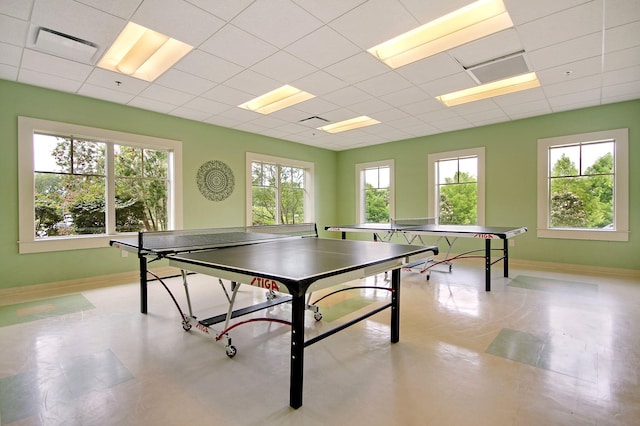 rec room featuring a drop ceiling and baseboards