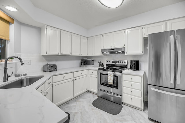 kitchen with a sink, white cabinets, under cabinet range hood, appliances with stainless steel finishes, and marble finish floor