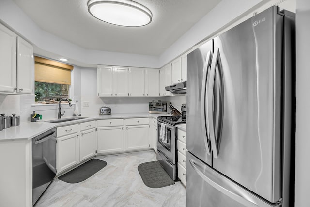 kitchen featuring a sink, light countertops, under cabinet range hood, appliances with stainless steel finishes, and white cabinetry