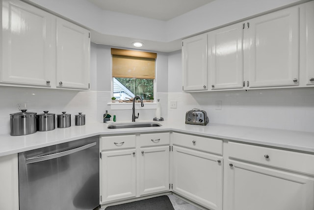 kitchen featuring stainless steel dishwasher, white cabinets, and a sink