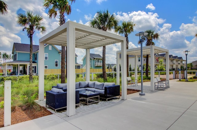 view of property's community featuring a pergola, an outdoor hangout area, and a patio