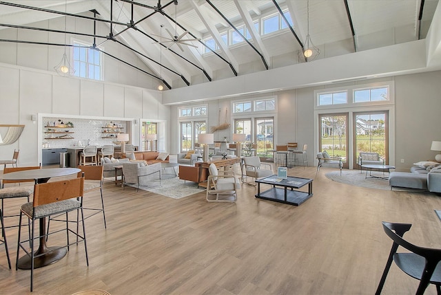 living room with ceiling fan, french doors, high vaulted ceiling, and hardwood / wood-style flooring