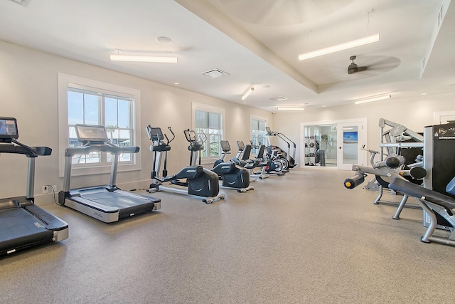 workout area featuring ceiling fan and a raised ceiling