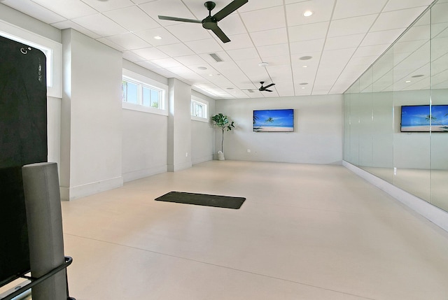 basement featuring a paneled ceiling and ceiling fan