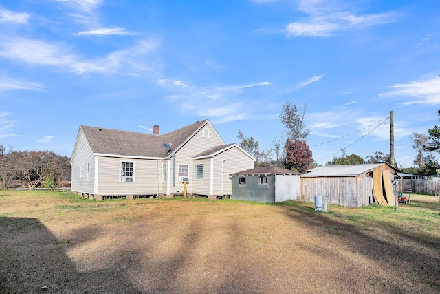 rear view of property with a yard and an outdoor structure