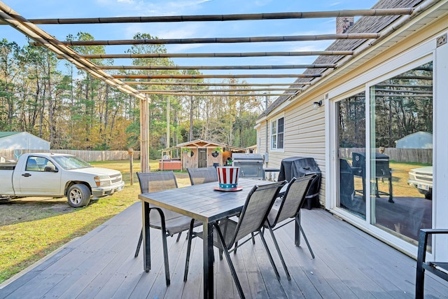 deck featuring a pergola, area for grilling, and a storage shed