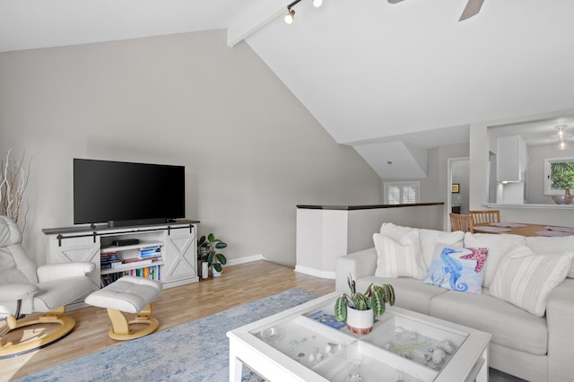 living area featuring beamed ceiling, high vaulted ceiling, wood finished floors, baseboards, and ceiling fan