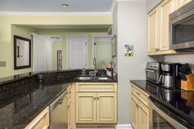 kitchen with cream cabinets, stainless steel appliances, crown molding, and a sink