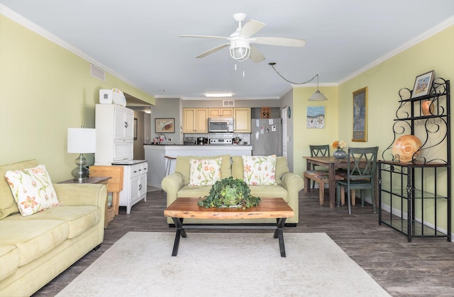 living room featuring ceiling fan, visible vents, dark wood finished floors, and crown molding