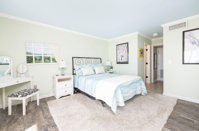 bedroom featuring crown molding, wood finished floors, visible vents, and baseboards