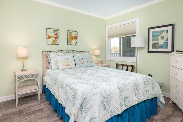 bedroom featuring baseboards, wood finished floors, and crown molding