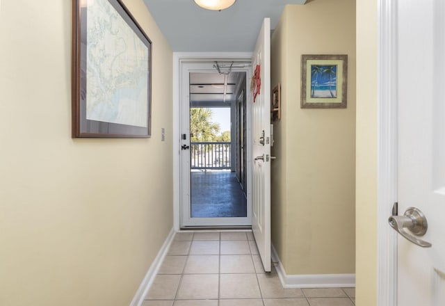 doorway to outside with light tile patterned floors and baseboards