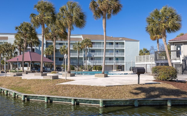 exterior space with a gazebo, a pool, and a water view