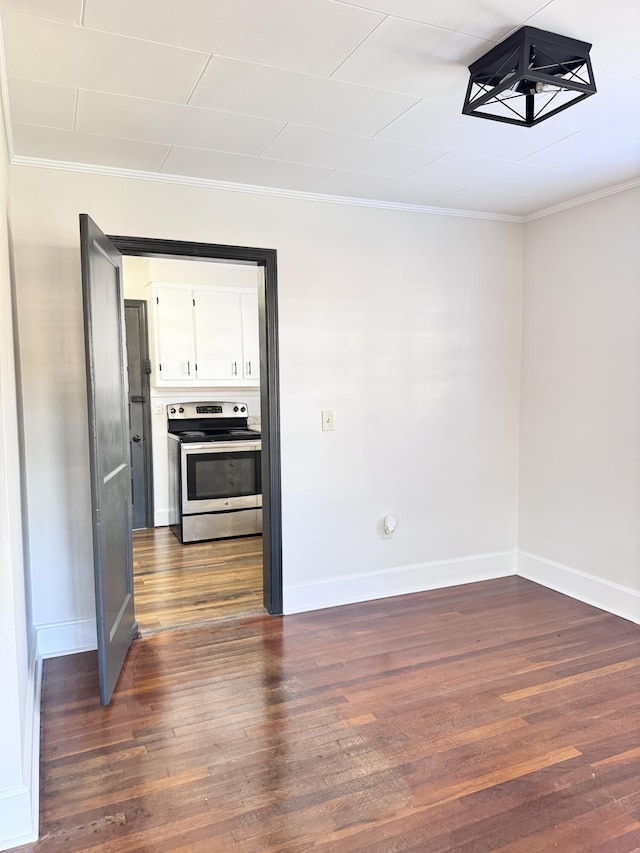 unfurnished room with dark hardwood / wood-style flooring and ornamental molding