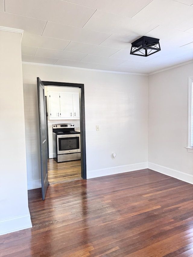 spare room featuring dark hardwood / wood-style floors and ornamental molding