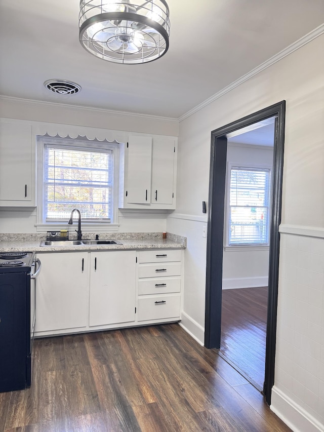 kitchen featuring white cabinets, black range oven, sink, ornamental molding, and dark hardwood / wood-style flooring