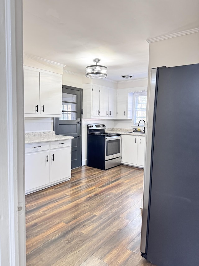 kitchen featuring crown molding, dark hardwood / wood-style floors, appliances with stainless steel finishes, white cabinetry, and a chandelier