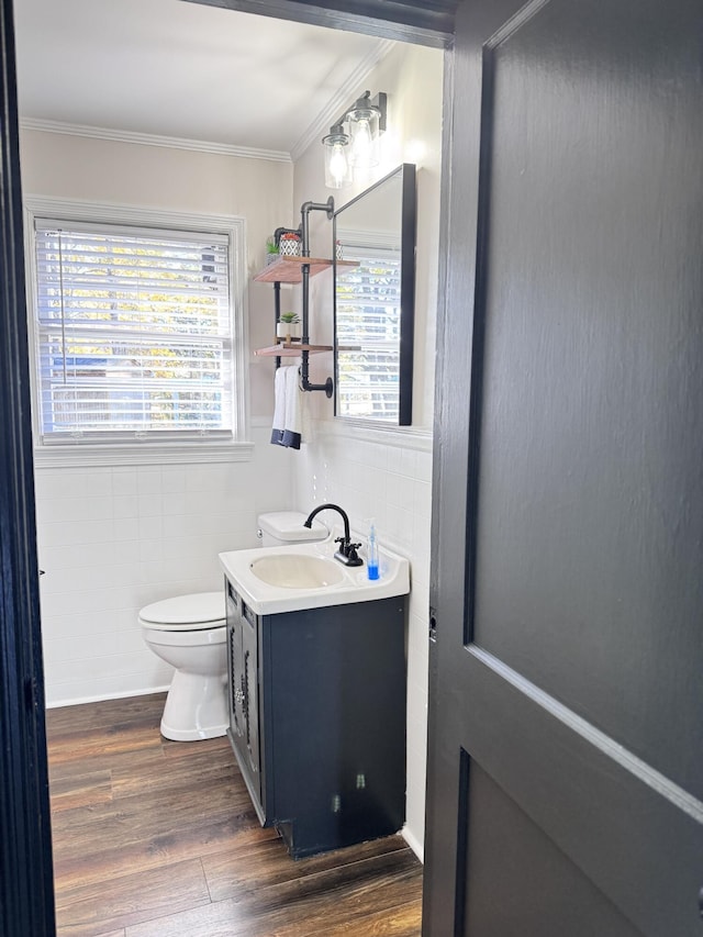 bathroom featuring wood-type flooring, vanity, toilet, and crown molding