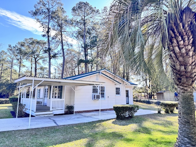 view of side of home featuring a yard, cooling unit, and a porch