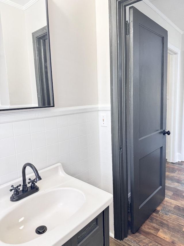 bathroom with hardwood / wood-style flooring, vanity, tile walls, and ornamental molding