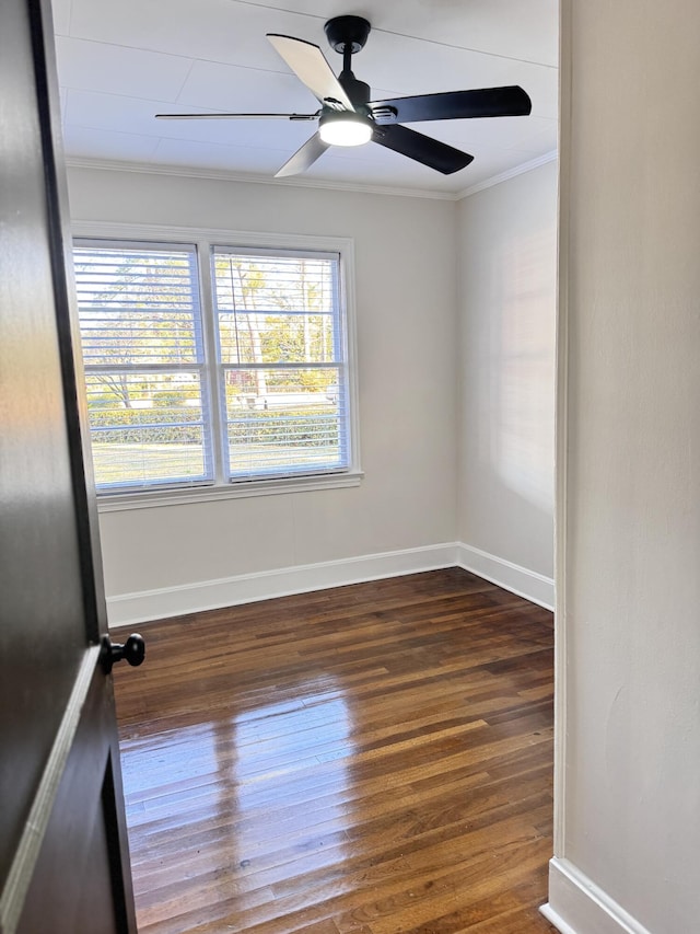 spare room featuring ceiling fan, ornamental molding, and dark wood-type flooring