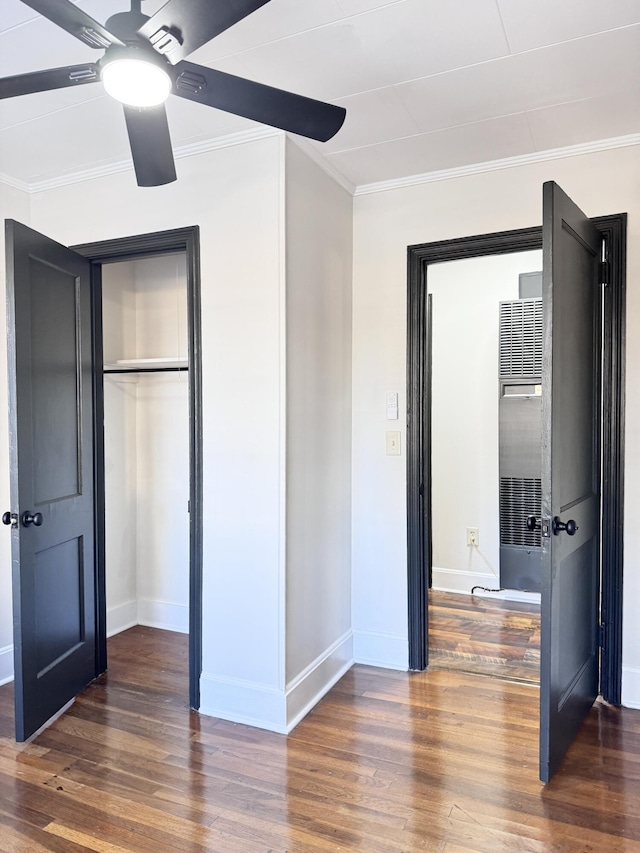 unfurnished bedroom featuring crown molding, ceiling fan, and dark wood-type flooring