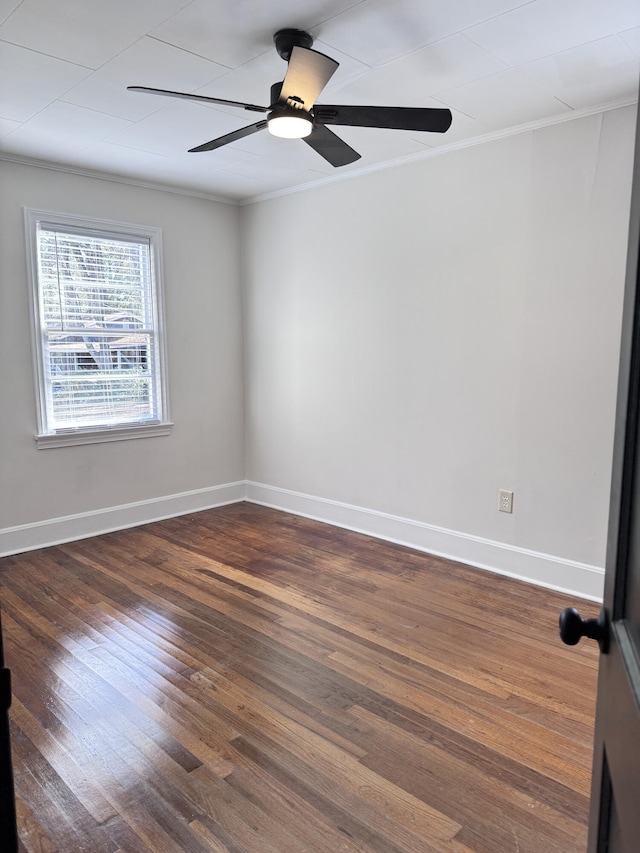 empty room featuring dark wood-type flooring and ornamental molding