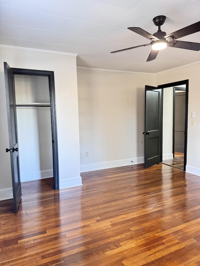 unfurnished bedroom featuring ceiling fan, dark hardwood / wood-style floors, and ornamental molding