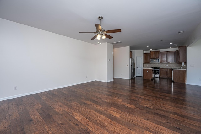 unfurnished living room featuring ceiling fan, recessed lighting, dark wood finished floors, and baseboards