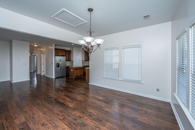 unfurnished living room featuring dark wood-style floors, plenty of natural light, visible vents, and baseboards