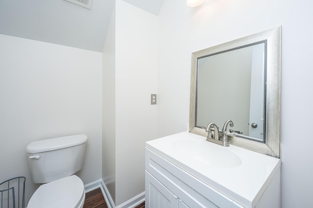 bathroom featuring wood finished floors, vanity, toilet, and baseboards