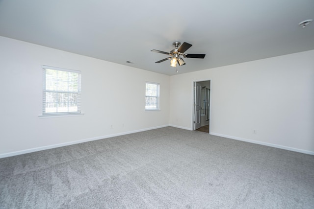 empty room featuring carpet floors, visible vents, baseboards, and a ceiling fan