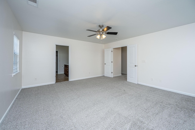 carpeted empty room featuring visible vents, ceiling fan, and baseboards