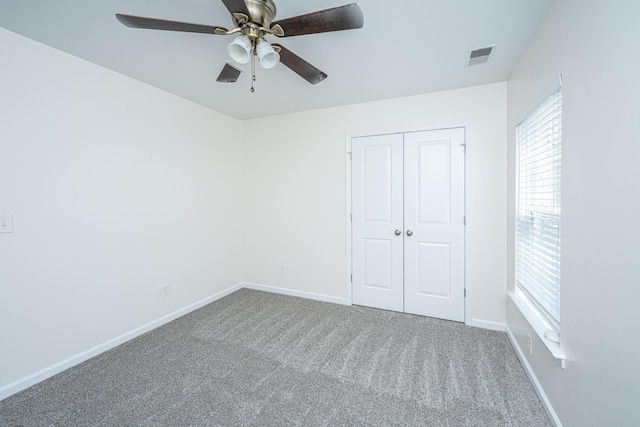 unfurnished bedroom featuring baseboards, visible vents, ceiling fan, carpet flooring, and a closet