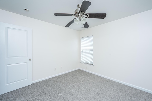 carpeted empty room with ceiling fan and baseboards