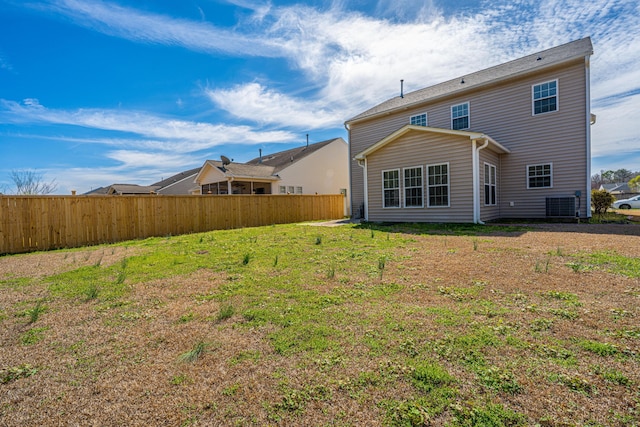 back of house featuring a lawn, fence, and central air condition unit