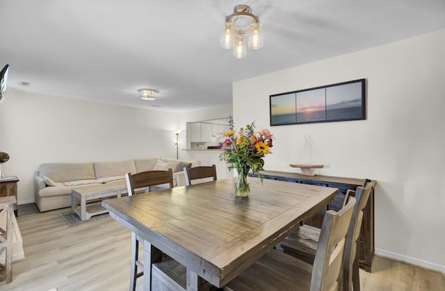 dining space with light wood-style flooring and baseboards