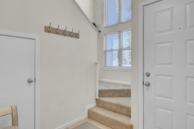 staircase with baseboards and tile patterned flooring