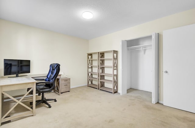 carpeted office space featuring baseboards and a textured ceiling