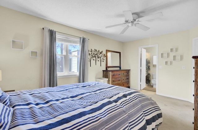 bedroom featuring light colored carpet, connected bathroom, baseboards, and ceiling fan