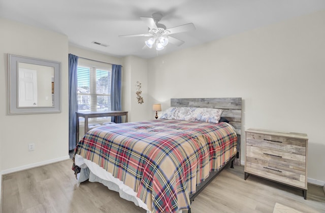 bedroom featuring visible vents, ceiling fan, baseboards, and wood finished floors