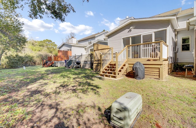 back of house featuring a yard, a deck, and stairs