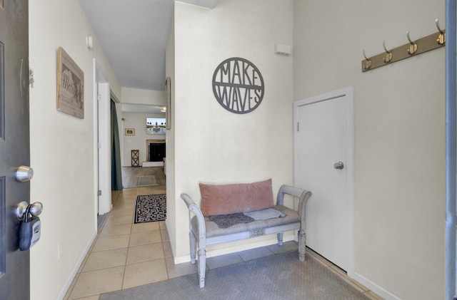 hall featuring light tile patterned floors and baseboards