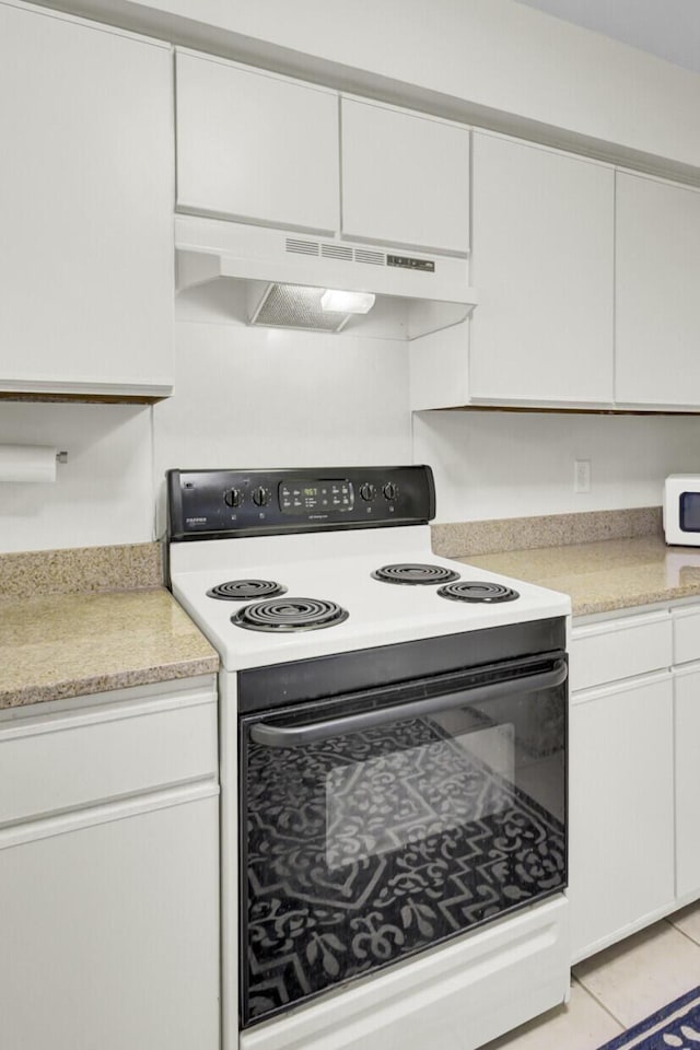 kitchen with white microwave, light tile patterned flooring, range with electric cooktop, light countertops, and under cabinet range hood