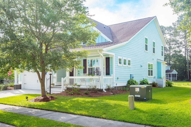 view of front of house with a garage, a front lawn, and covered porch